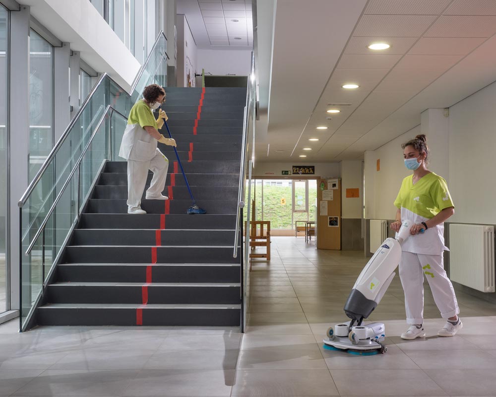 Dos trabajadoras de Zaintzen realizando labores de limpieza en un edificio